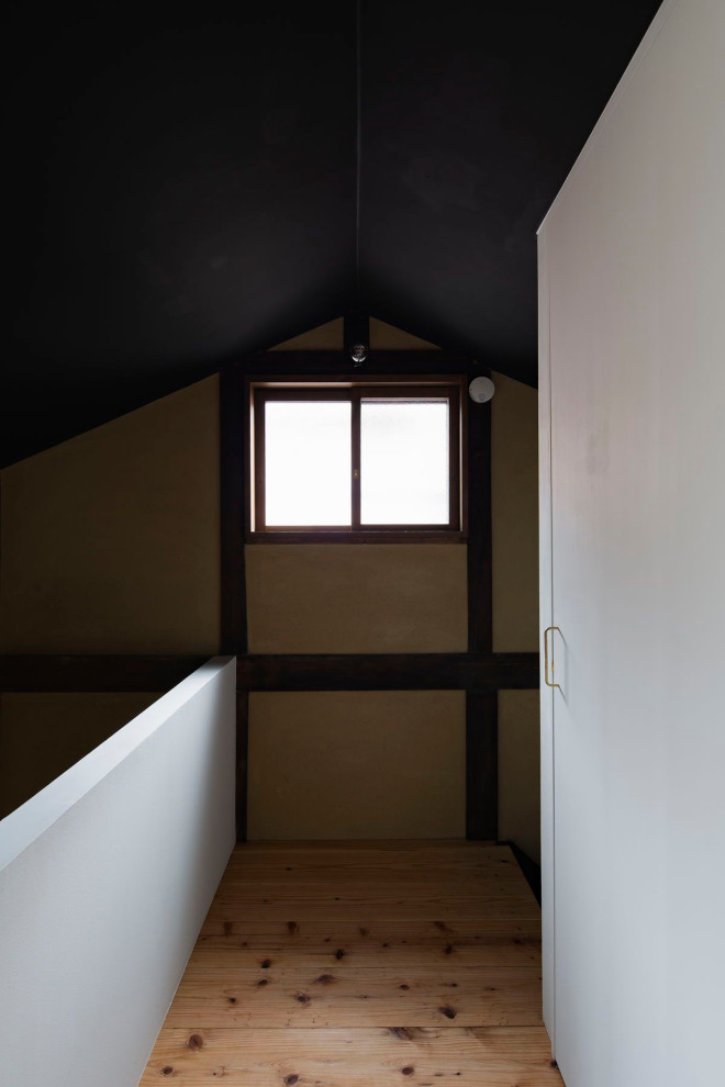 Cette photo montre un couloir chic de taille moyenne avec un mur marron, parquet clair et un sol beige.