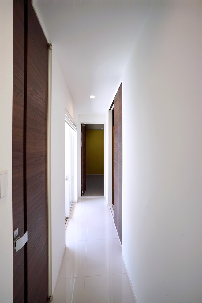 На фото: большой коридор в стиле модернизм с белыми стенами, белым полом, потолком с обоями и обоями на стенах