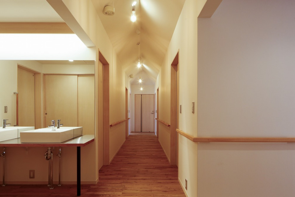 Diseño de recibidores y pasillos nórdicos grandes con paredes blancas y suelo de madera en tonos medios