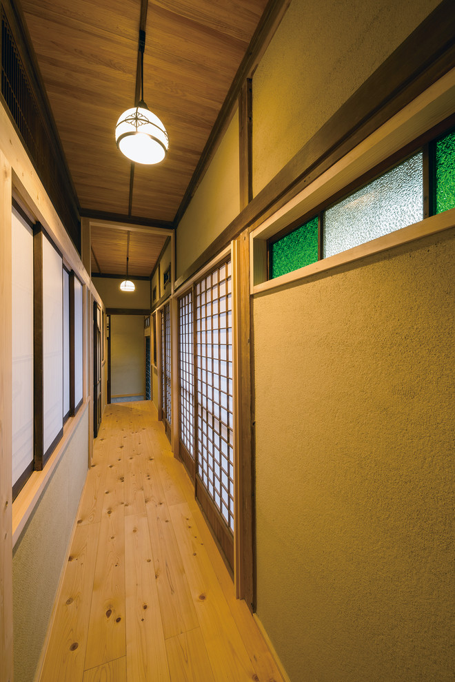 Esempio di un ingresso o corridoio etnico con pareti marroni, pavimento in legno massello medio e pavimento marrone