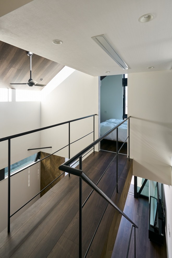Imagen de recibidores y pasillos modernos con paredes blancas, suelo de madera oscura y suelo marrón