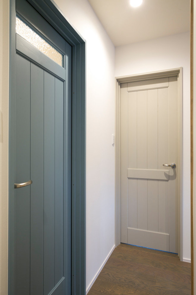 Immagine di un ingresso o corridoio scandinavo con pareti bianche, pavimento in legno massello medio, pavimento marrone, soffitto in carta da parati e carta da parati