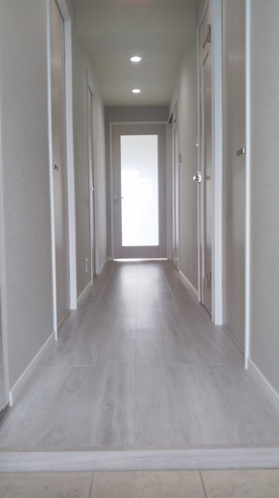 Ispirazione per un piccolo ingresso o corridoio minimalista con pareti grigie, pavimento in compensato, pavimento bianco, soffitto in carta da parati e carta da parati