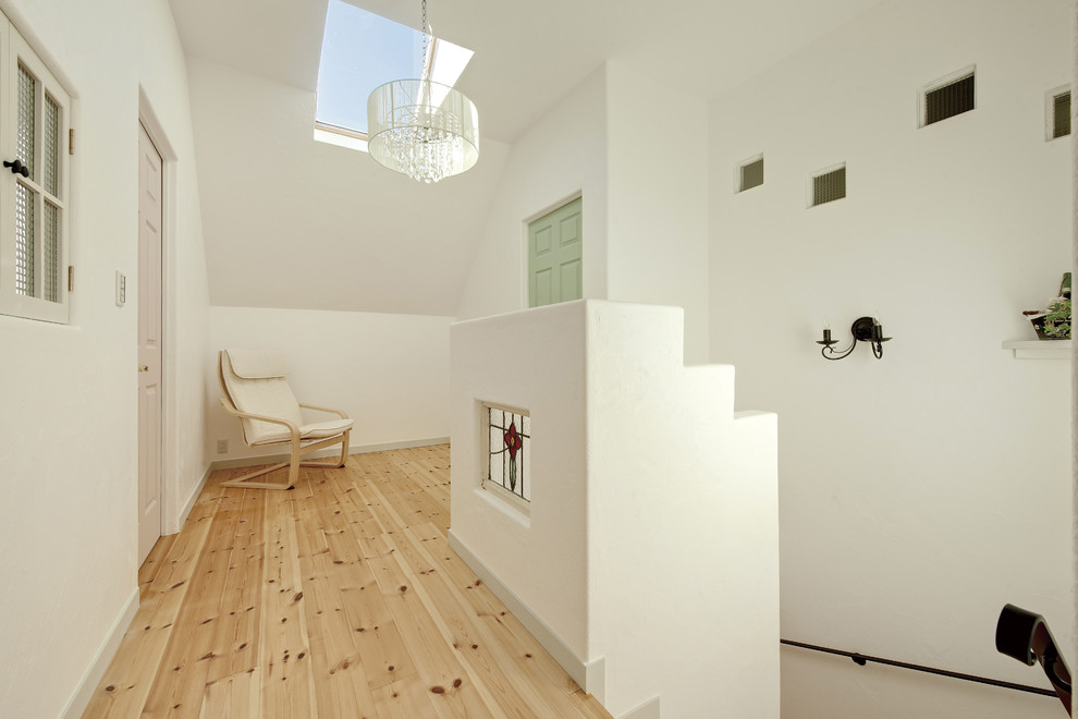 Ejemplo de recibidores y pasillos de estilo zen pequeños con suelo de madera clara y suelo marrón