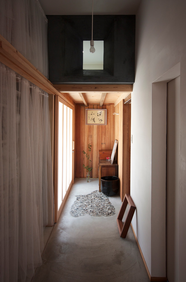 Modelo de recibidores y pasillos de estilo zen con paredes blancas y suelo de cemento