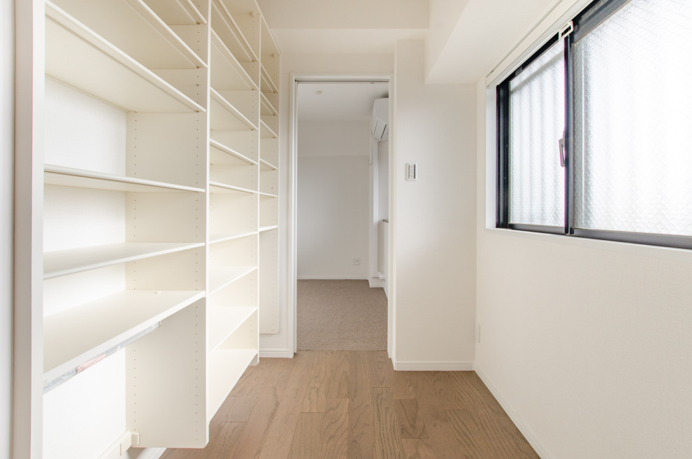 Kleiner Moderner Flur mit weißer Wandfarbe, braunem Holzboden, braunem Boden, Tapetendecke und Tapetenwänden in Sonstige