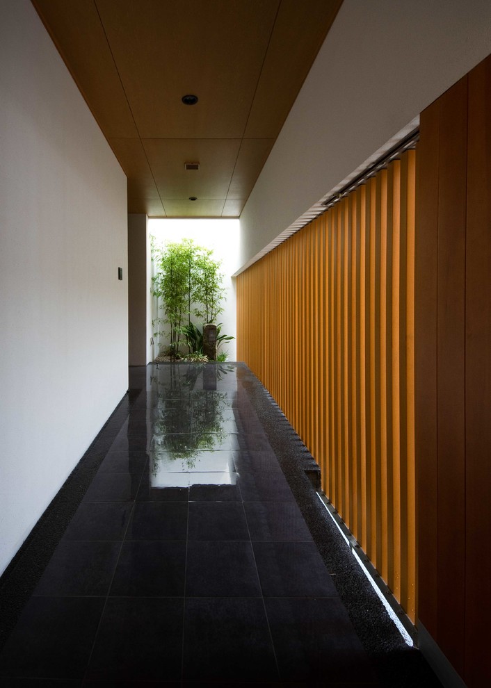 На фото: большой коридор в восточном стиле с белыми стенами и полом из сланца