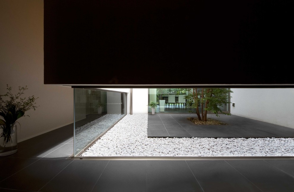 Cette photo montre un grand couloir asiatique avec un mur blanc et un sol en ardoise.