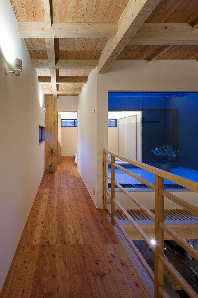 Diseño de recibidores y pasillos modernos con paredes blancas, suelo de madera clara y suelo beige