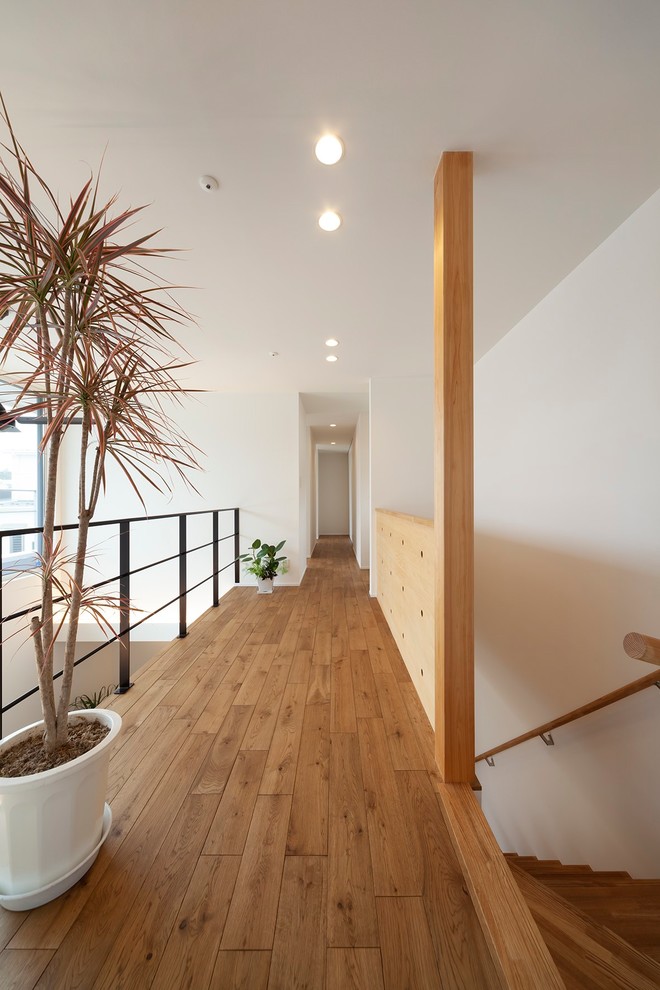 Стильный дизайн: коридор в скандинавском стиле с белыми стенами, коричневым полом и паркетным полом среднего тона - последний тренд