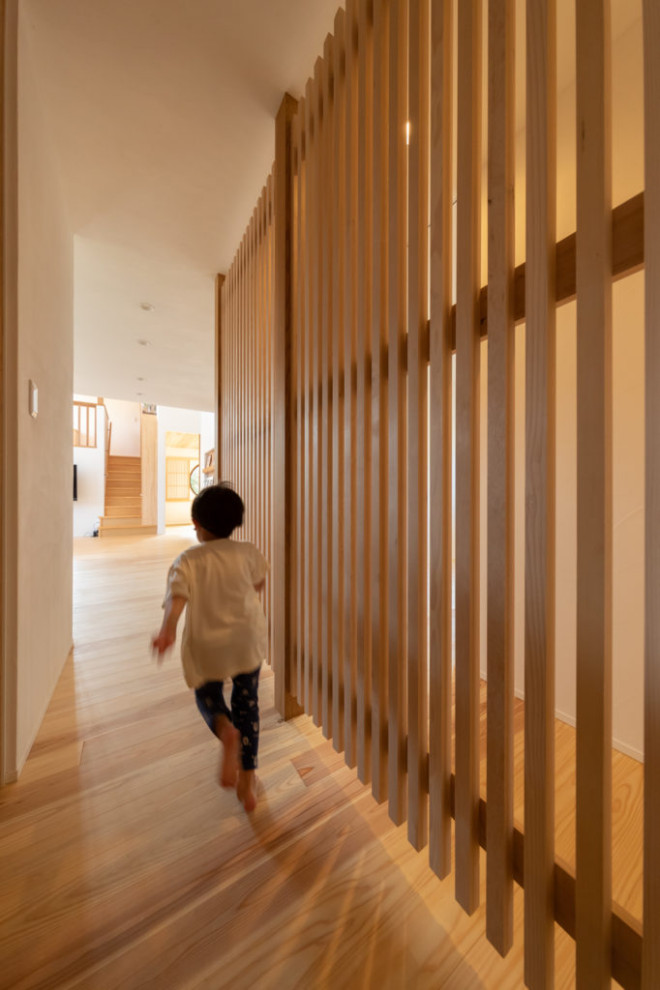 Exempel på en minimalistisk hall, med vita väggar, mellanmörkt trägolv och brunt golv