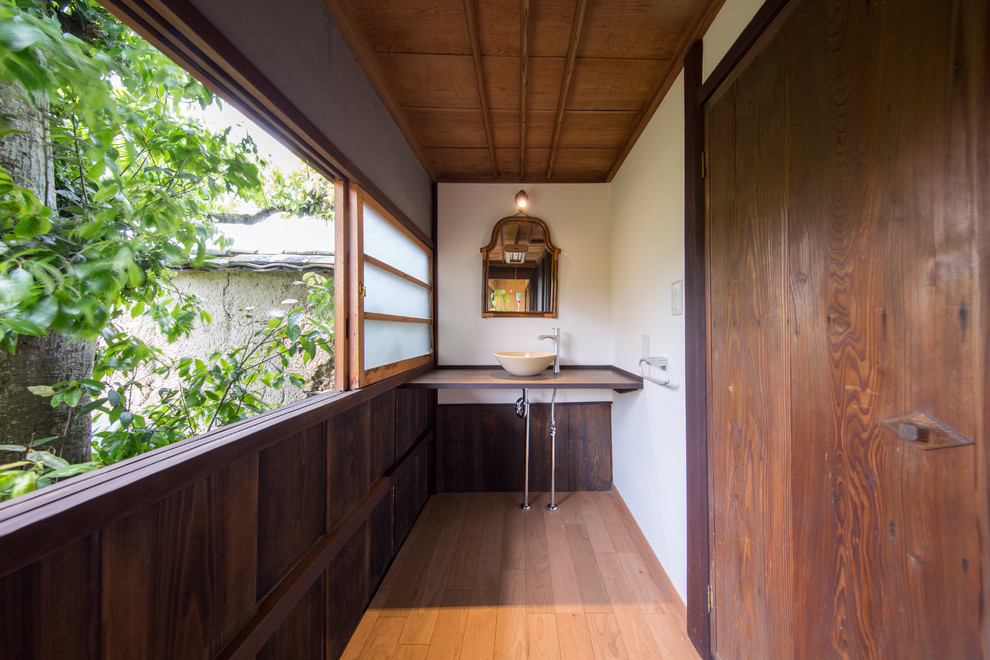 Imagen de recibidores y pasillos de estilo zen con paredes blancas, suelo de madera en tonos medios y suelo marrón