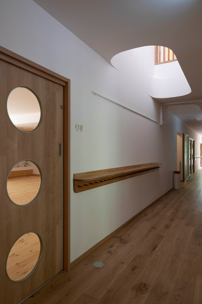Immagine di un ampio ingresso o corridoio chic con pareti bianche, parquet chiaro, pavimento beige, soffitto in carta da parati e carta da parati