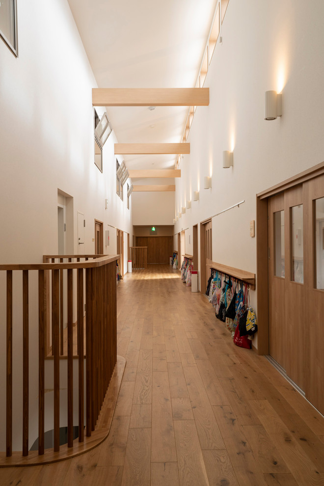 Imagen de recibidores y pasillos tradicionales extra grandes con paredes blancas, suelo de madera clara, suelo beige, papel pintado y papel pintado