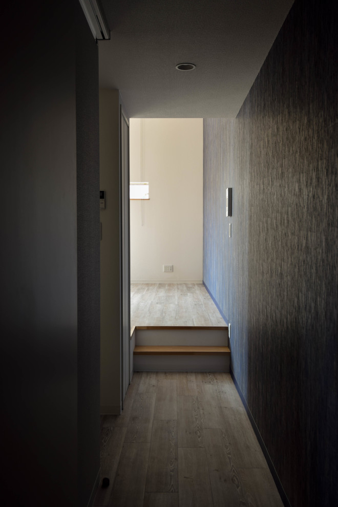 Cette image montre un couloir minimaliste de taille moyenne avec parquet peint et un sol beige.