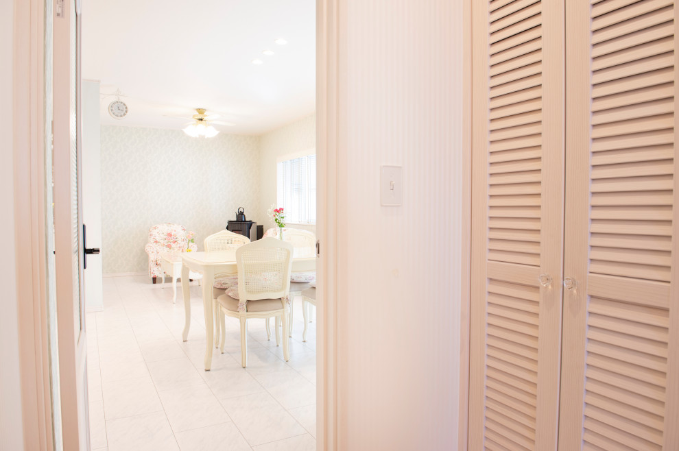 Aménagement d'un petit couloir romantique avec un mur blanc, un sol en contreplaqué et un sol blanc.