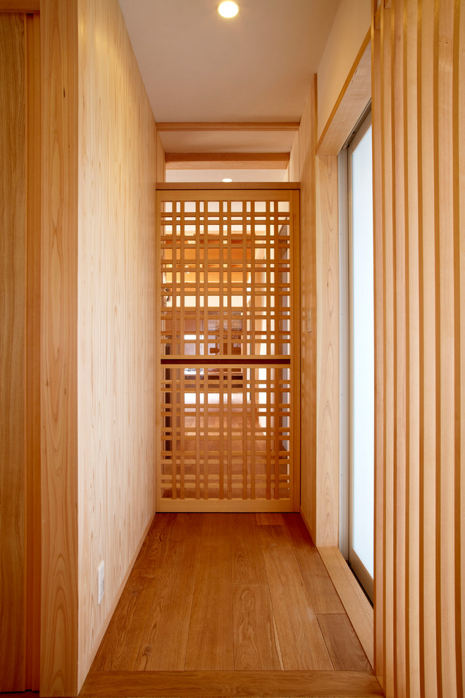 Inspiration för en orientalisk hall, med vita väggar, mellanmörkt trägolv och beiget golv