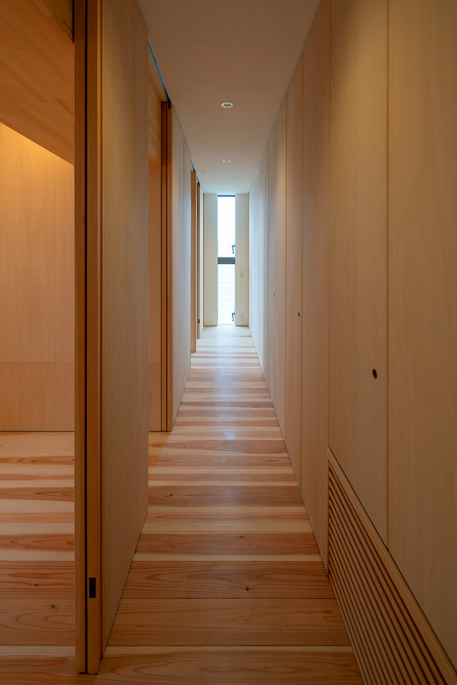 Esempio di un ingresso o corridoio etnico con pareti bianche, pavimento in legno massello medio e pavimento beige