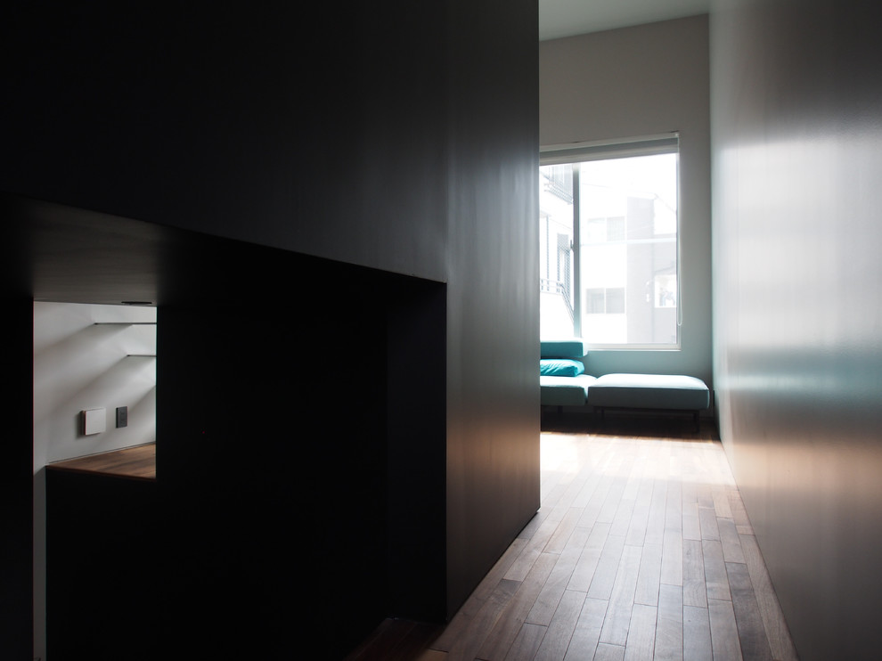 Стильный дизайн: коридор в стиле лофт с черными стенами, темным паркетным полом и коричневым полом - последний тренд