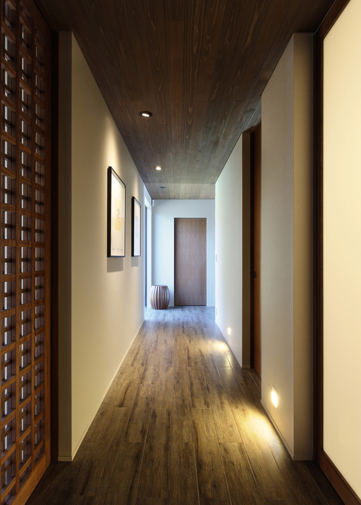 Inspiration pour un couloir minimaliste avec un sol marron.