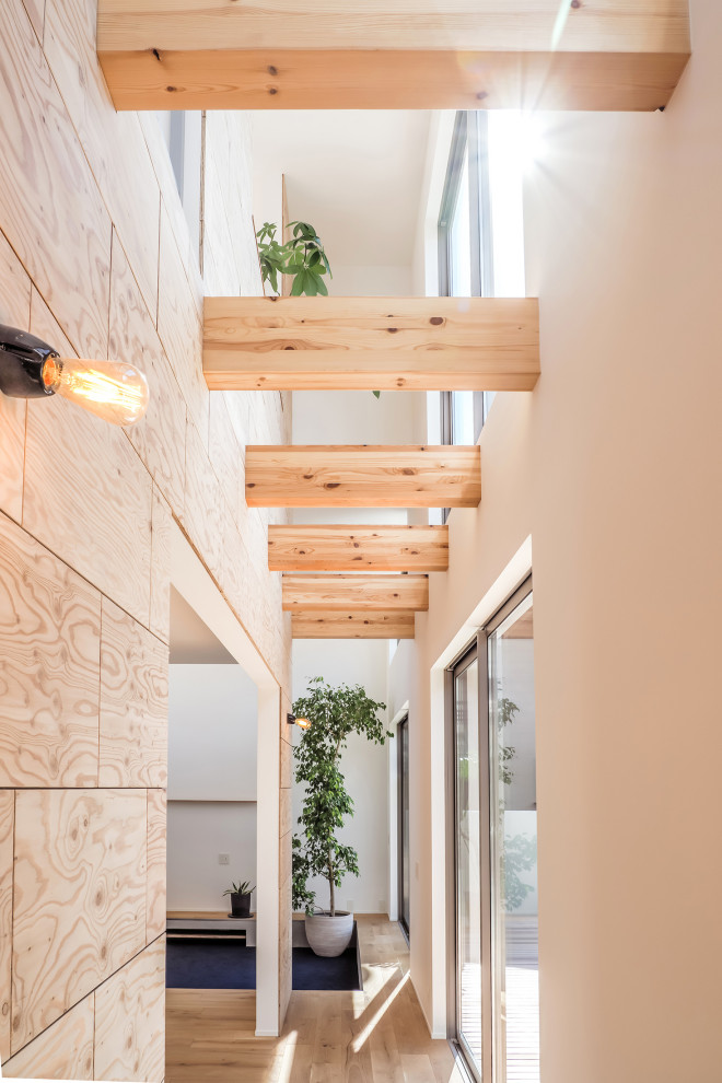 Cette image montre un couloir design en bois avec un mur blanc, parquet clair et un plafond en papier peint.