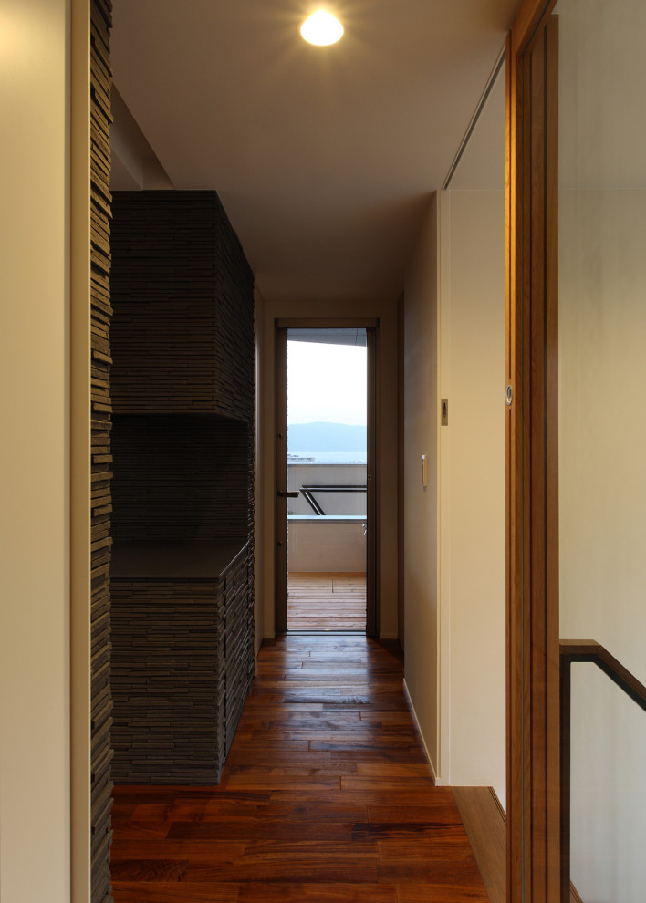 Idéer för en mellanstor modern hall, med svarta väggar, mörkt trägolv och brunt golv