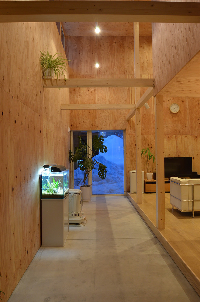 На фото: маленький коридор в современном стиле с бетонным полом, серым полом и коричневыми стенами для на участке и в саду с