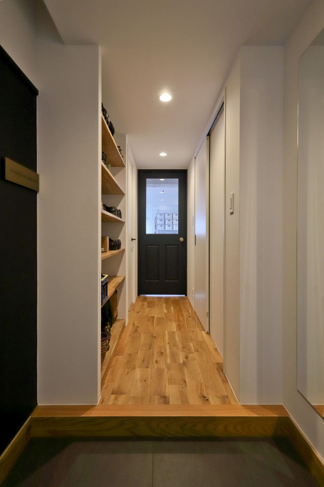 Example of a small trendy medium tone wood floor, beige floor, shiplap wall and wallpaper ceiling hallway design in Tokyo Suburbs with white walls