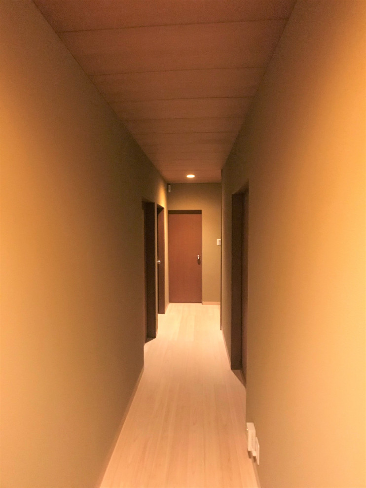 Cette image montre un couloir asiatique de taille moyenne avec un mur beige, parquet clair et un sol beige.