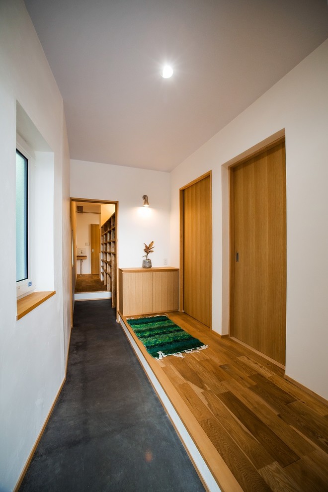 Diseño de recibidores y pasillos de estilo zen con paredes blancas y suelo gris