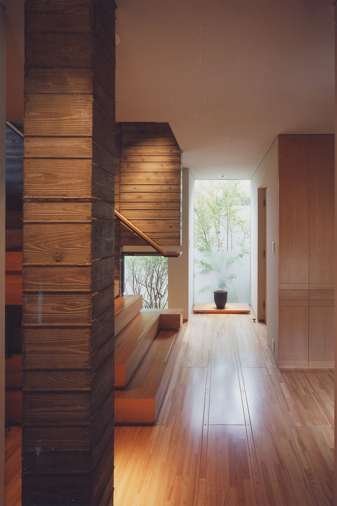 Diseño de recibidores y pasillos de estilo zen con paredes blancas, suelo de madera clara y suelo beige