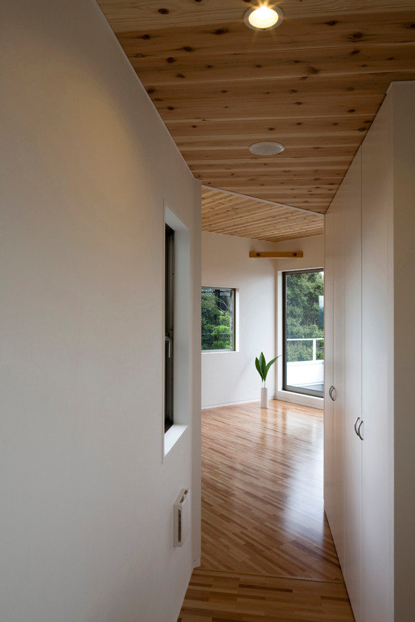 Imagen de recibidores y pasillos modernos pequeños con paredes blancas, suelo de contrachapado, suelo marrón, madera y papel pintado