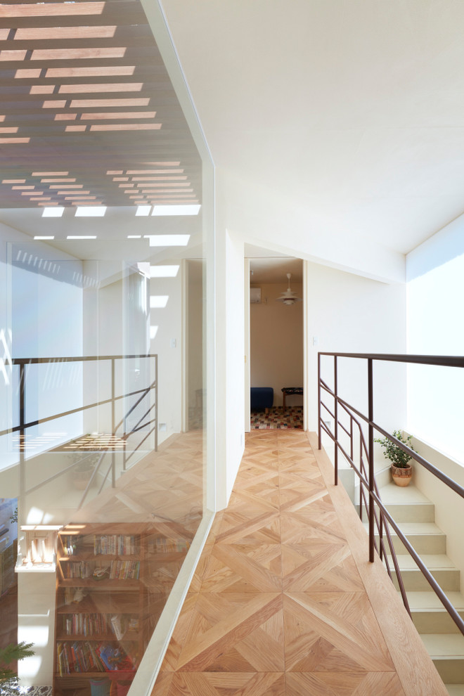 Diseño de recibidores y pasillos actuales con paredes blancas, suelo de madera en tonos medios y suelo marrón
