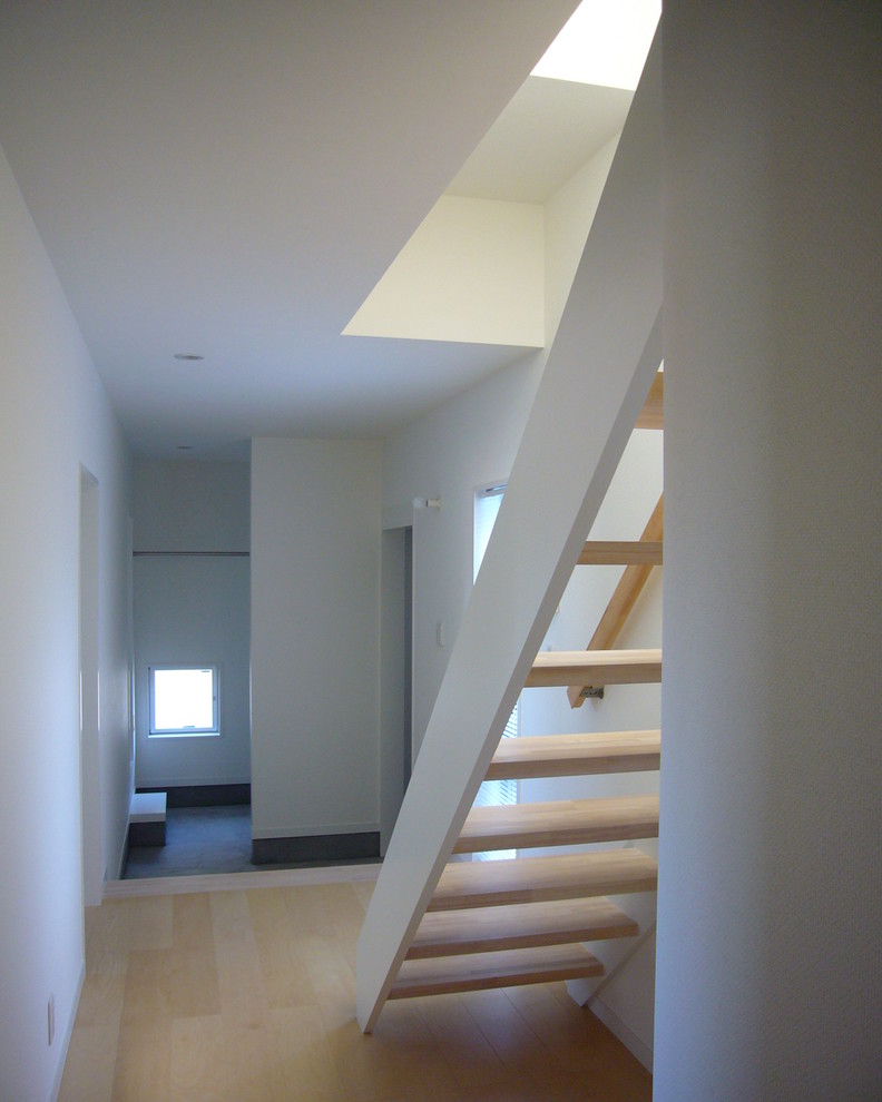 Imagen de recibidores y pasillos minimalistas de tamaño medio con paredes blancas, suelo de contrachapado y suelo beige