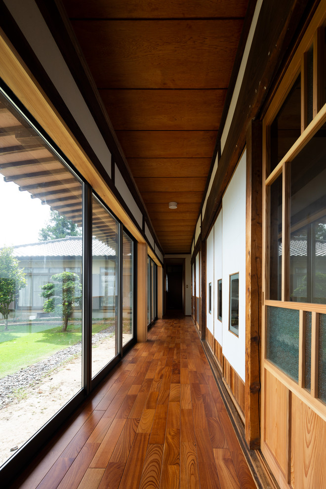 Modelo de recibidores y pasillos de estilo zen con suelo de madera oscura y suelo marrón
