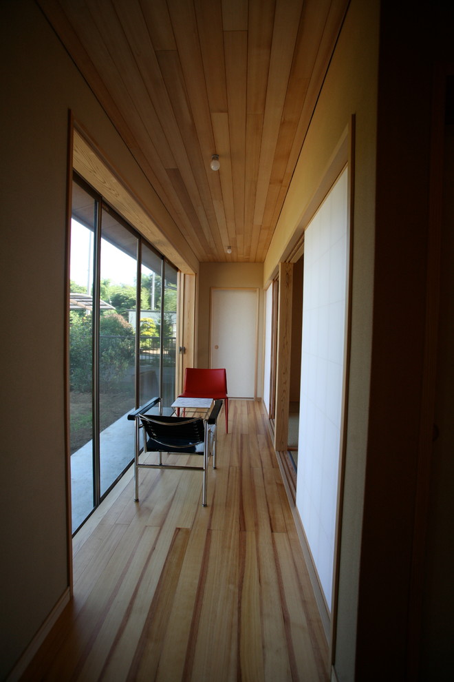 Modelo de recibidores y pasillos de estilo zen pequeños con paredes beige, suelo de madera clara y suelo beige