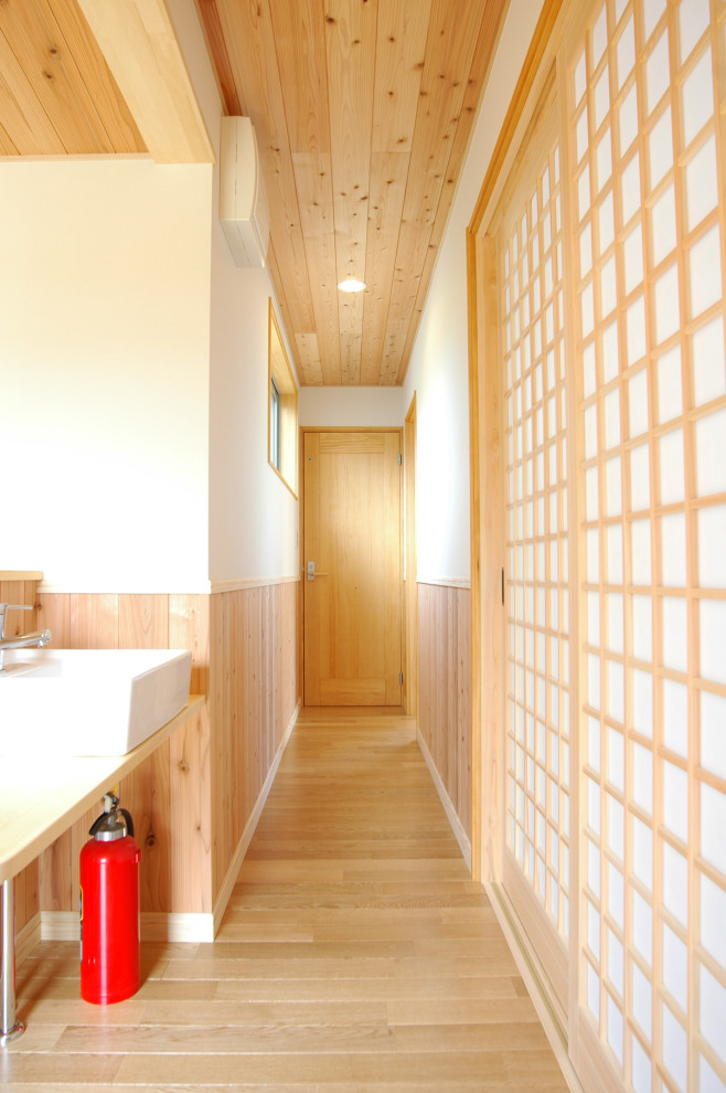 Diseño de recibidores y pasillos asiáticos de tamaño medio con paredes blancas, suelo de madera en tonos medios, suelo marrón, madera y madera