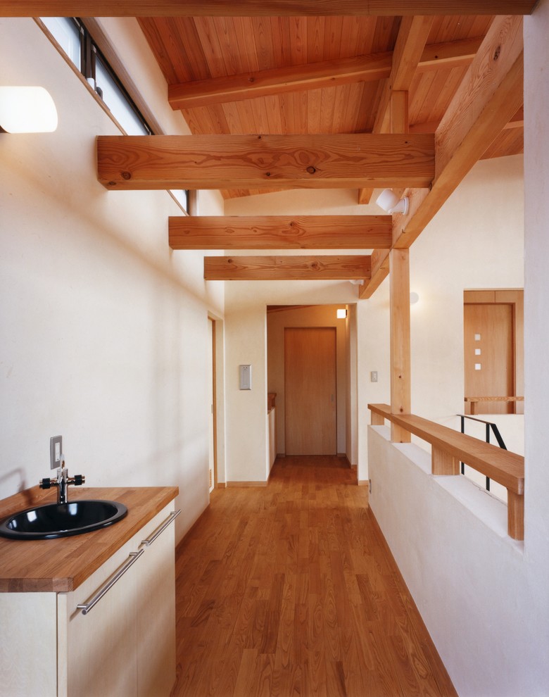 Idée de décoration pour un couloir champêtre avec un mur blanc, un sol en bois brun et un sol marron.