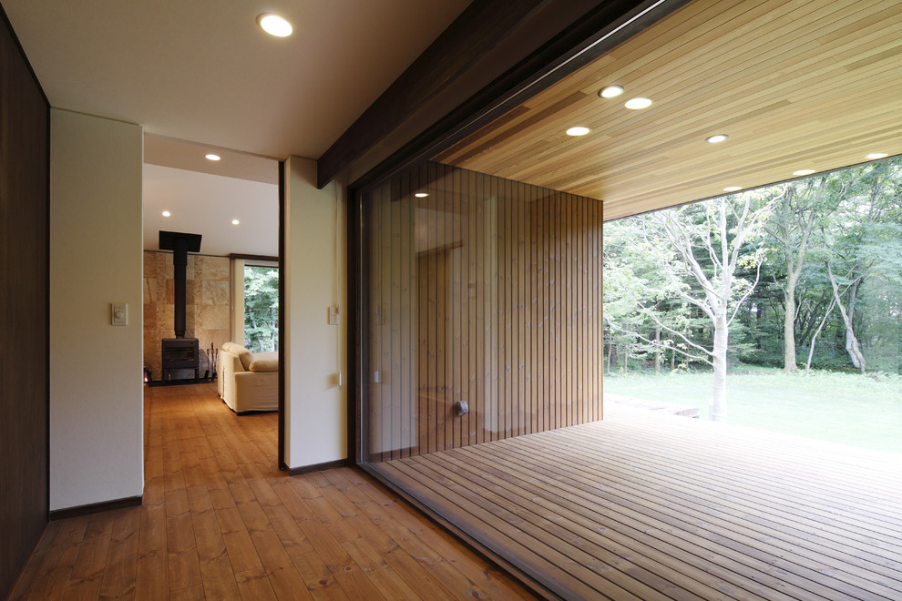 Ejemplo de recibidores y pasillos modernos de tamaño medio con paredes blancas, suelo de madera en tonos medios y suelo marrón