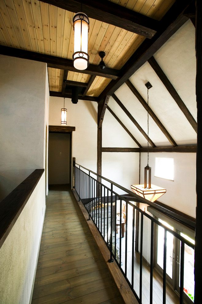 Idée de décoration pour un couloir chalet avec un mur blanc, un sol en bois brun et un sol marron.