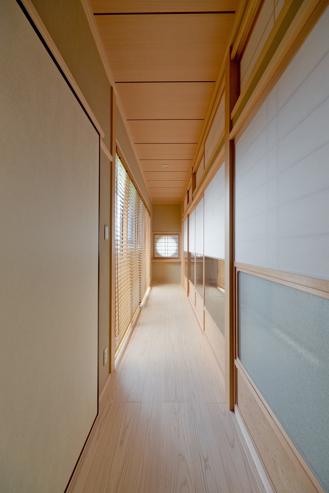 Aménagement d'un couloir asiatique avec un mur marron, parquet clair et un sol beige.