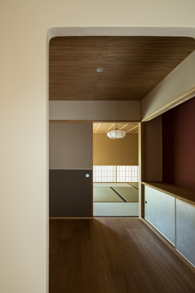 Diseño de recibidores y pasillos asiáticos con paredes blancas, suelo de madera oscura, madera y papel pintado