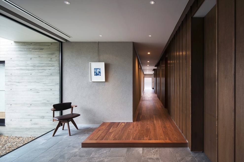 Свежая идея для дизайна: большой коридор в восточном стиле с серыми стенами, темным паркетным полом и коричневым полом - отличное фото интерьера
