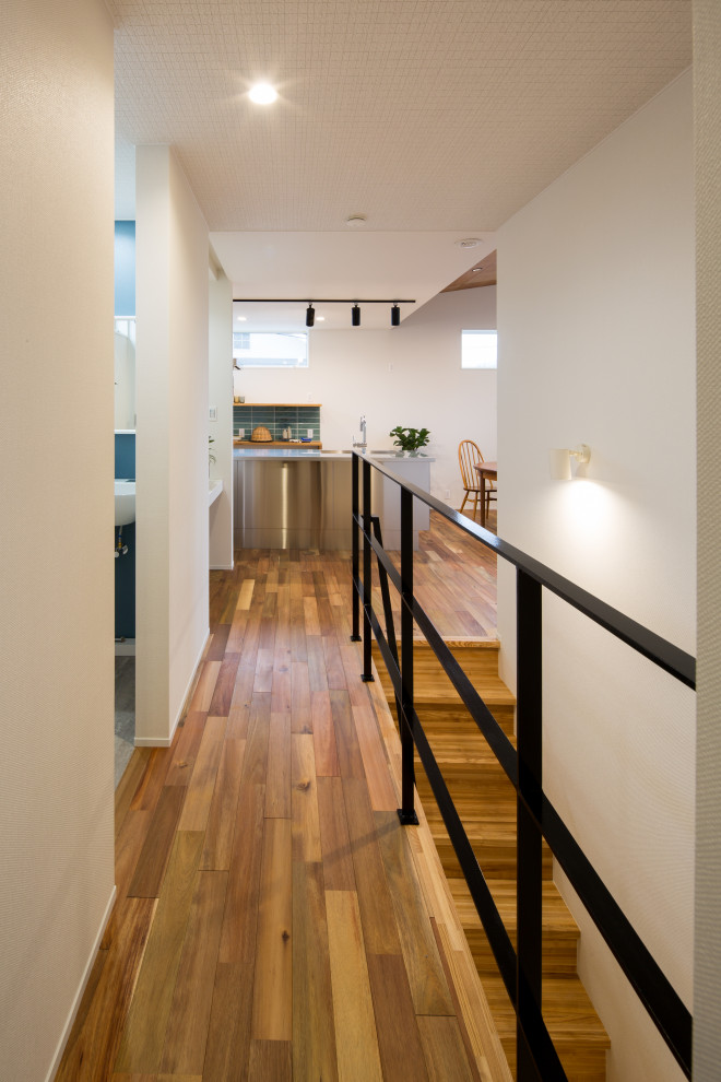 Idee per un ingresso o corridoio scandinavo con pareti bianche, pavimento in legno massello medio, pavimento marrone, soffitto in carta da parati e carta da parati