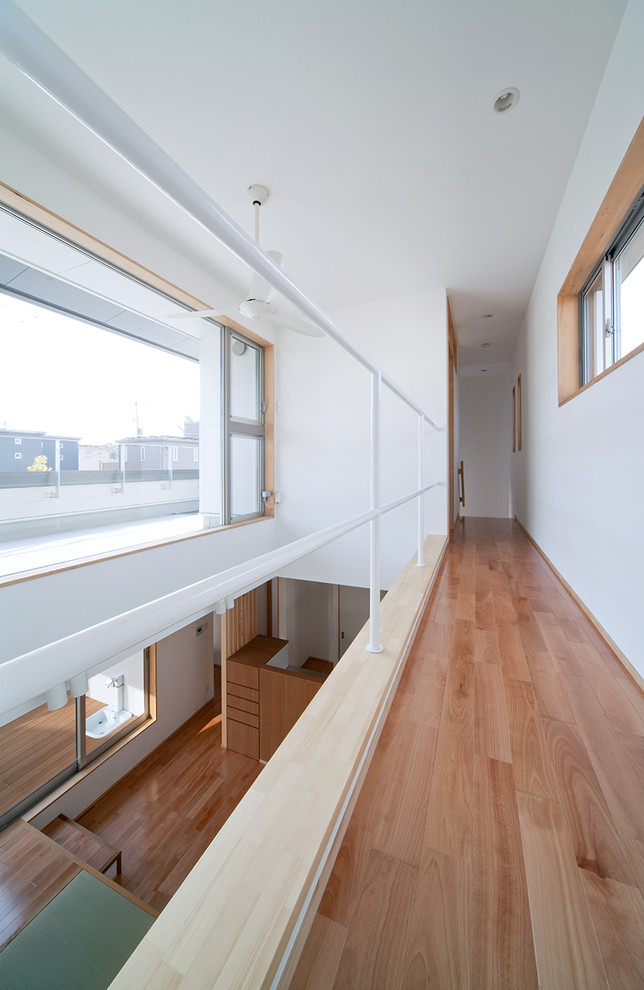 Imagen de recibidores y pasillos nórdicos con paredes blancas, suelo de madera en tonos medios y suelo marrón