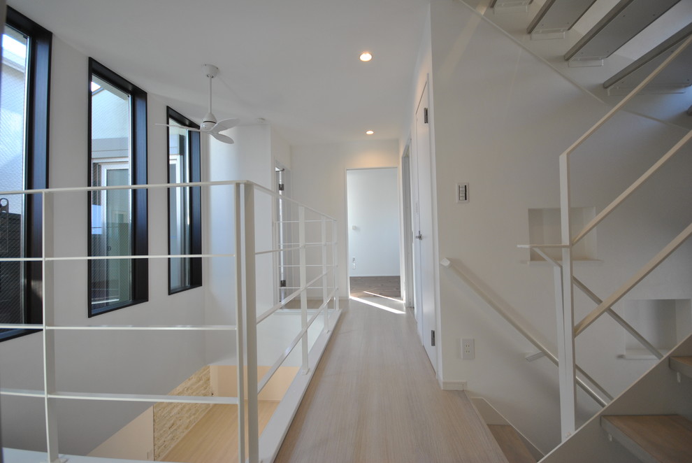 На фото: коридор среднего размера в стиле модернизм с белыми стенами, полом из фанеры и белым полом