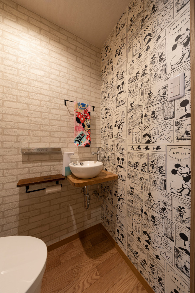 Idées déco pour une petite salle de bain industrielle pour enfant avec un carrelage gris, un mur multicolore, une vasque, un plan de toilette en bois, un sol marron et un plan de toilette beige.