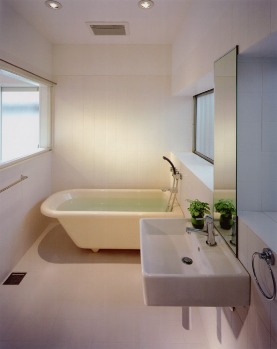 Medium sized world-inspired ensuite bathroom in Tokyo with a freestanding bath, a walk-in shower, white tiles and glass tiles.