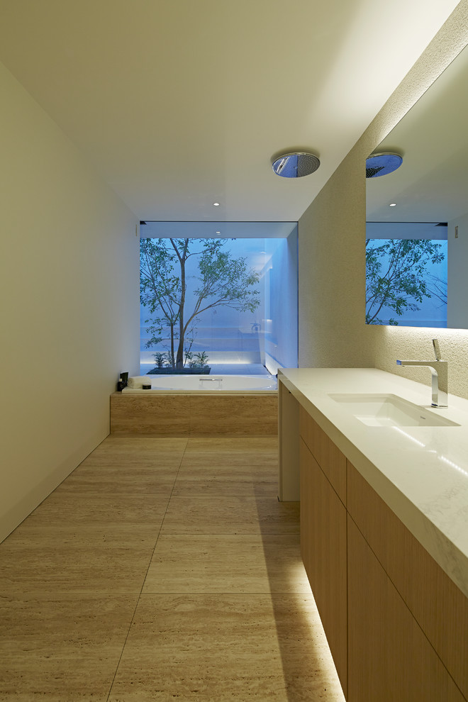 Modern inredning av ett vit vitt en-suite badrum, med luckor med profilerade fronter, skåp i ljust trä, en toalettstol med hel cisternkåpa, beige kakel, vita väggar, ett undermonterad handfat, bänkskiva i kvarts och beiget golv