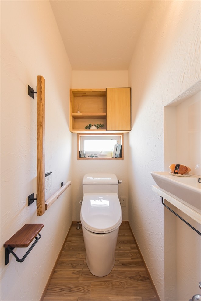 横浜にあるアジアンスタイルのおしゃれなトイレ・洗面所 (白い壁、無垢フローリング、茶色い床) の写真